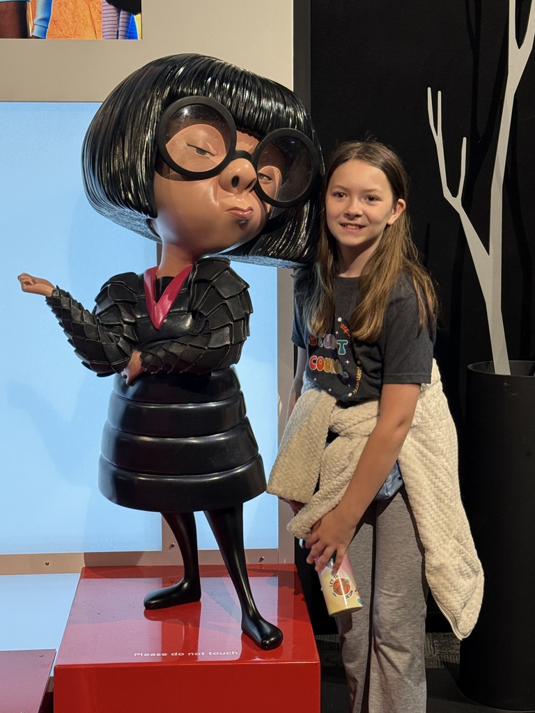 Student posing with PIXAR character statue