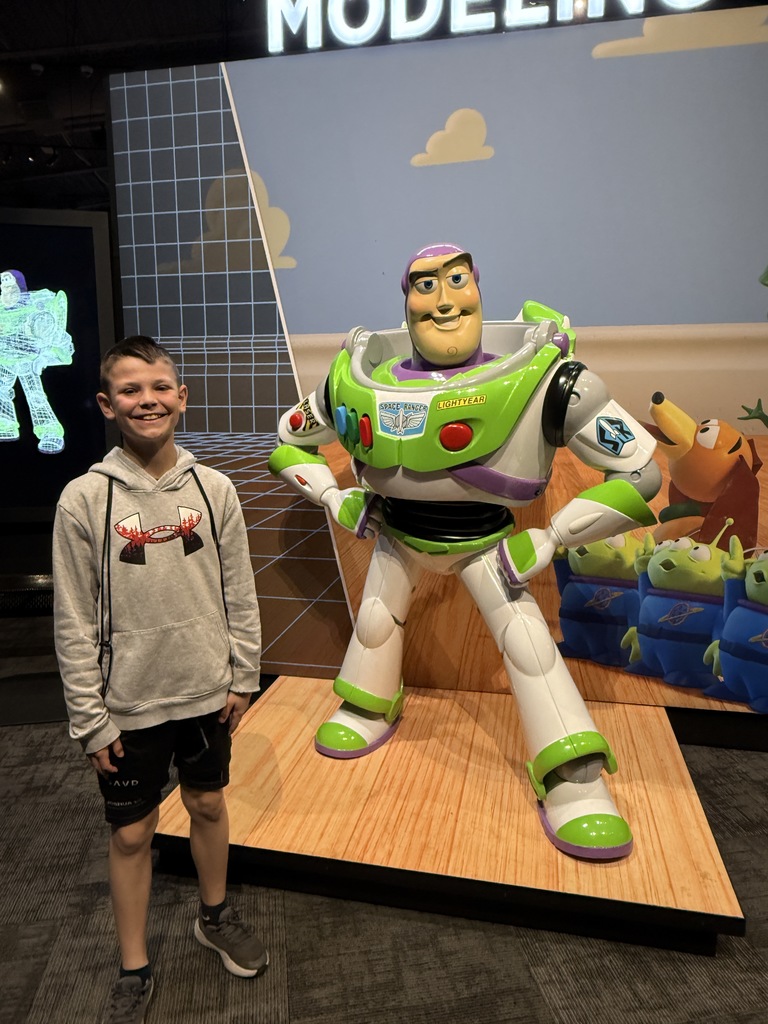 Student posing with Buzz Lightyear statue