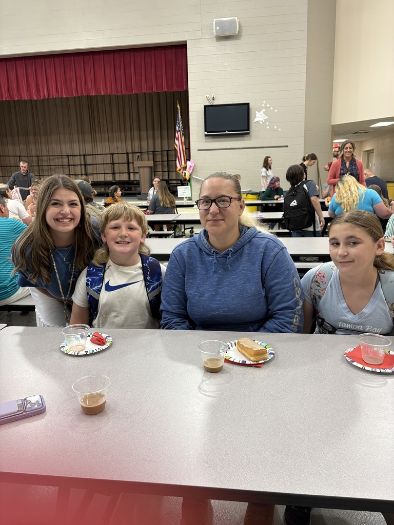 Student posing with their family members and teacher