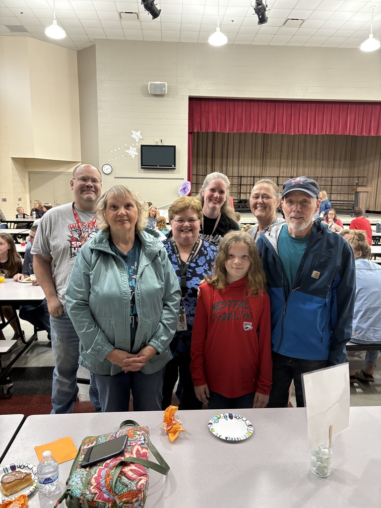 Student posing with their family members and teachers