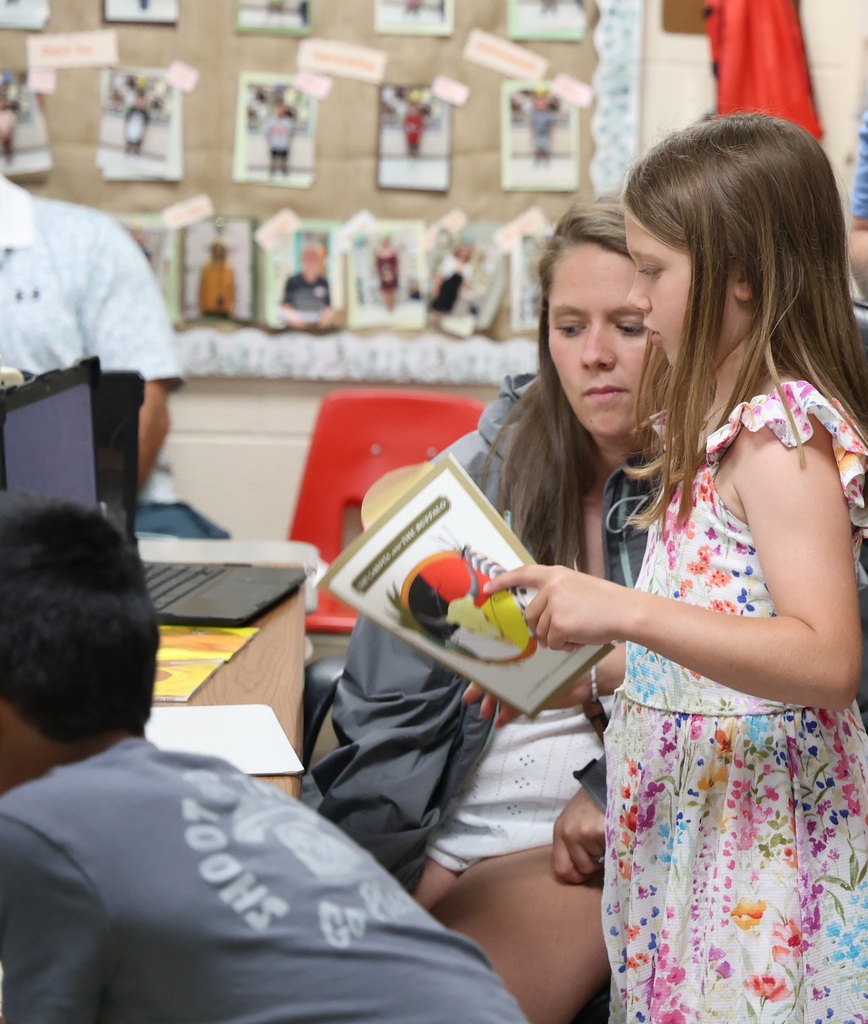 Students reading to their family members and guests