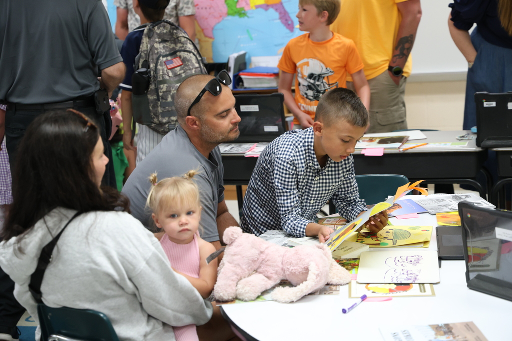 Students reading to their family members and guests