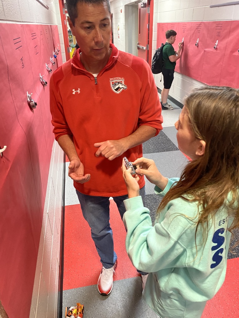 Teacher watching student figure out his combo lock