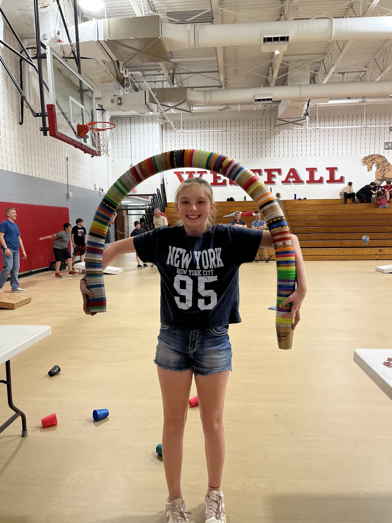 Girl holding a rainbow of stacked cups