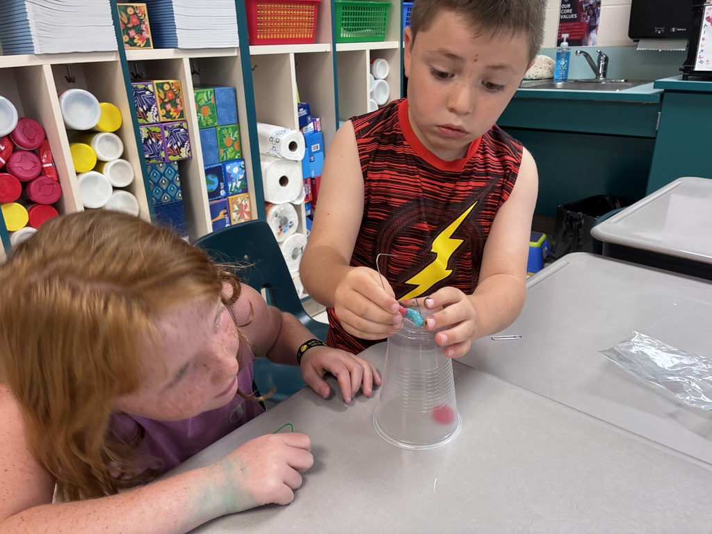 Students using paper clips to hold their gummy worm