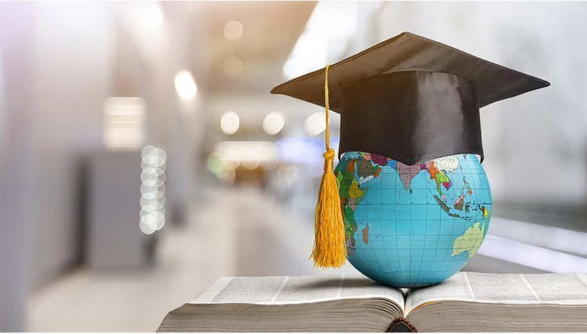 Globe with a graduation cap sitting on an open book