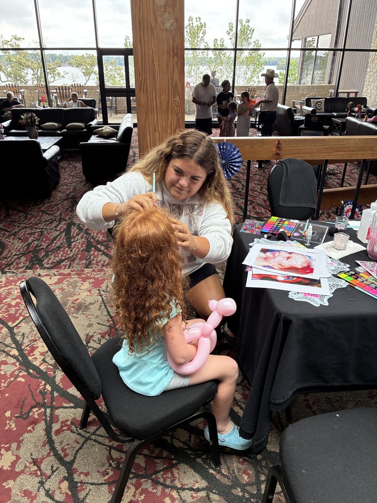 Student face painting a child's face