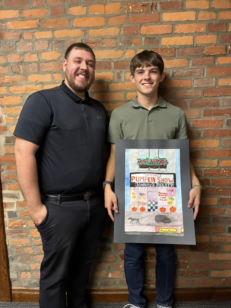 Grady Harrison with representative from The Savings Band holding Pumpkin Show artwork