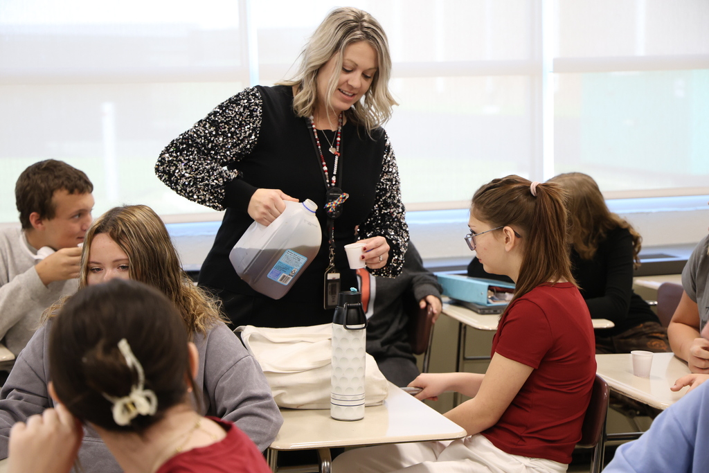 Mrs. Davey pouring sweet tea from a jug into a student's cup