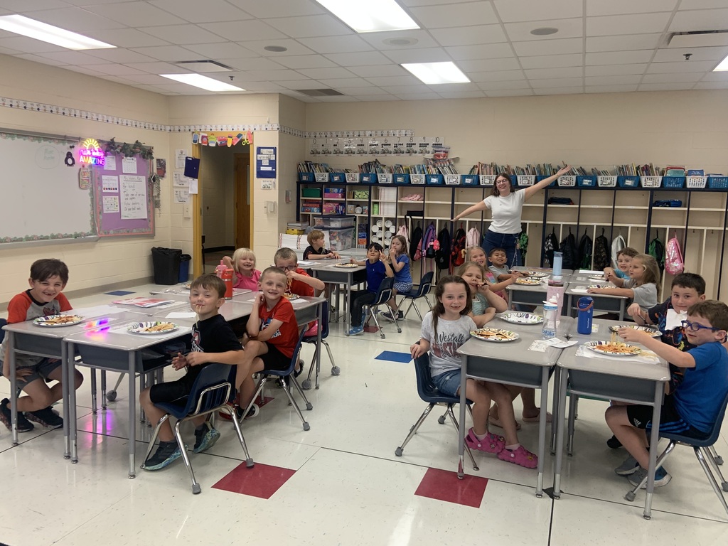 Classroom full of seated students and a teacher in the background