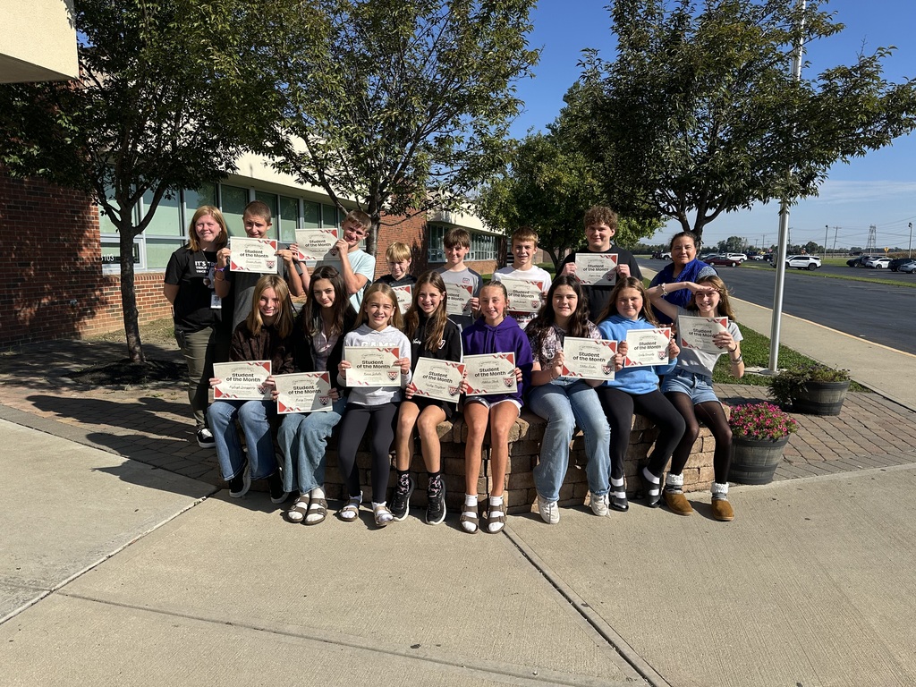 October Students of the Month sitting outside holding certificates