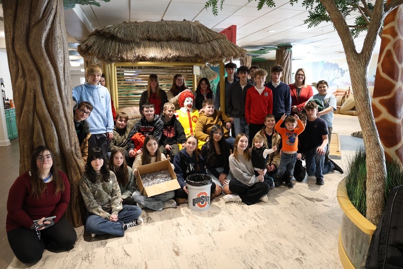 Students posing with statue of Ronald McDonald in the Ronald McDonald House in Columbus Ohio