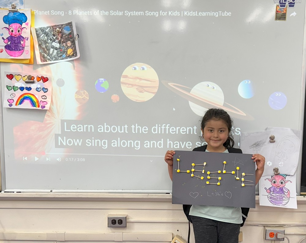 Students hold up solar system design