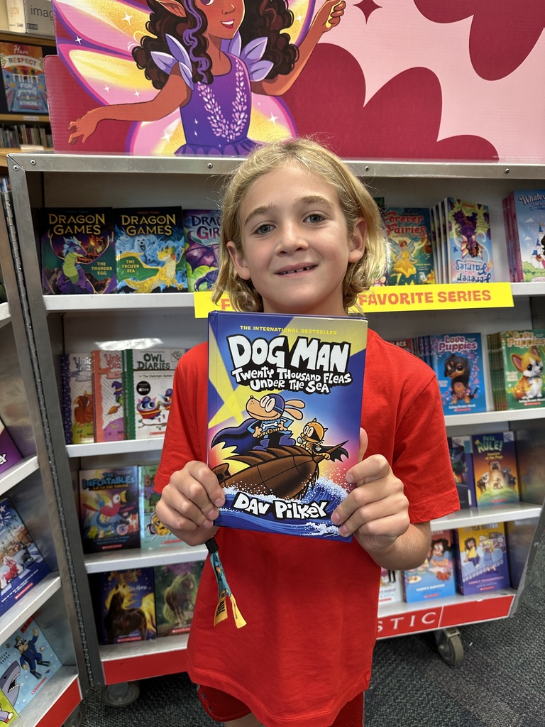 one student holding up their Book Fair book