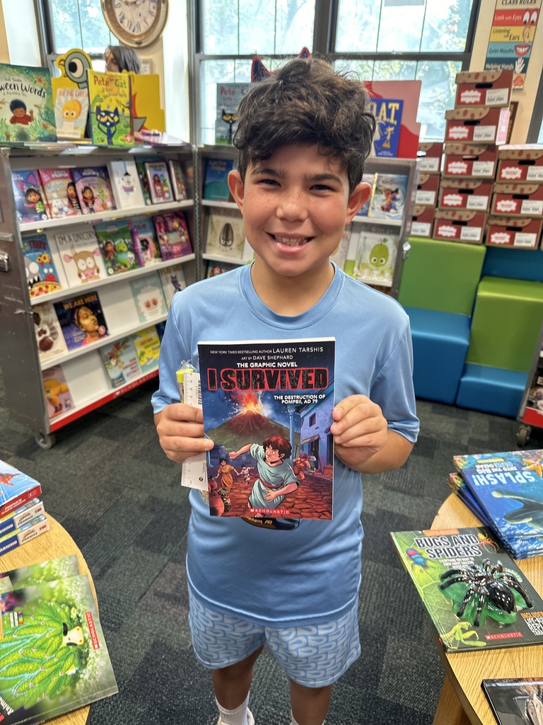 one student holding up their Book Fair book