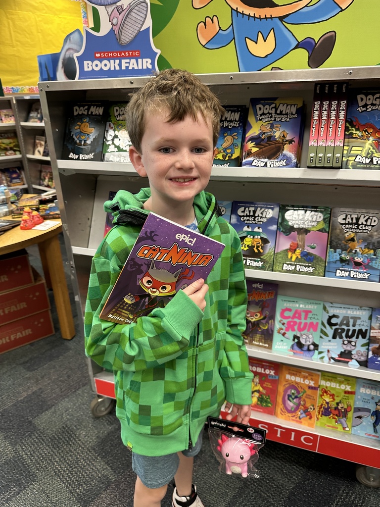 one student holding up their Book Fair book