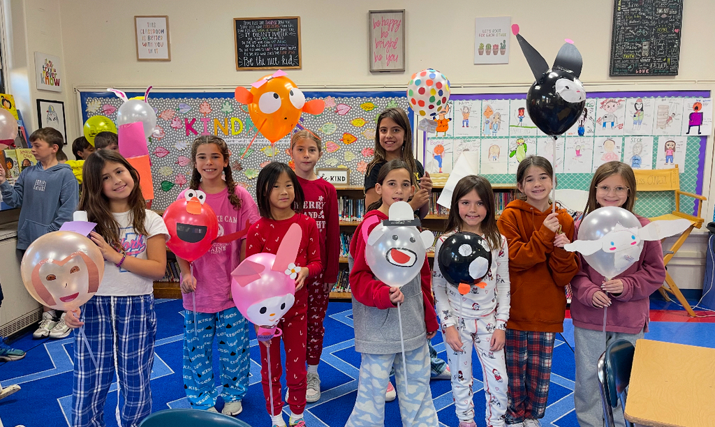 students holding their balloon designs