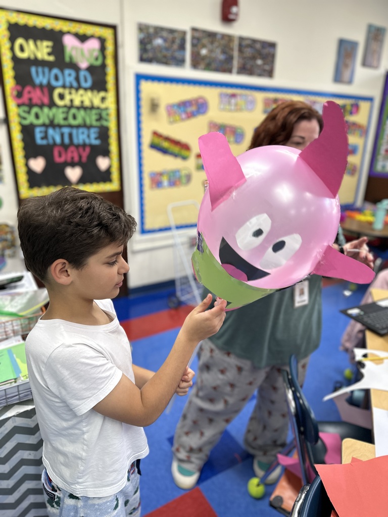 student holding their balloon design