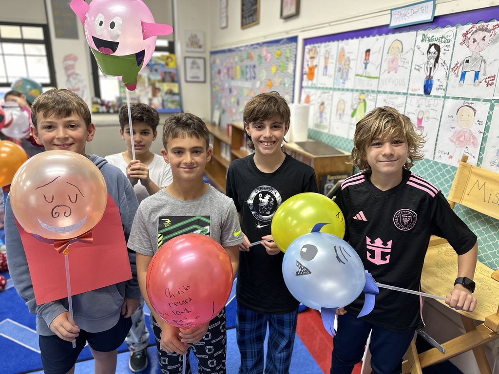students holding their balloon designs