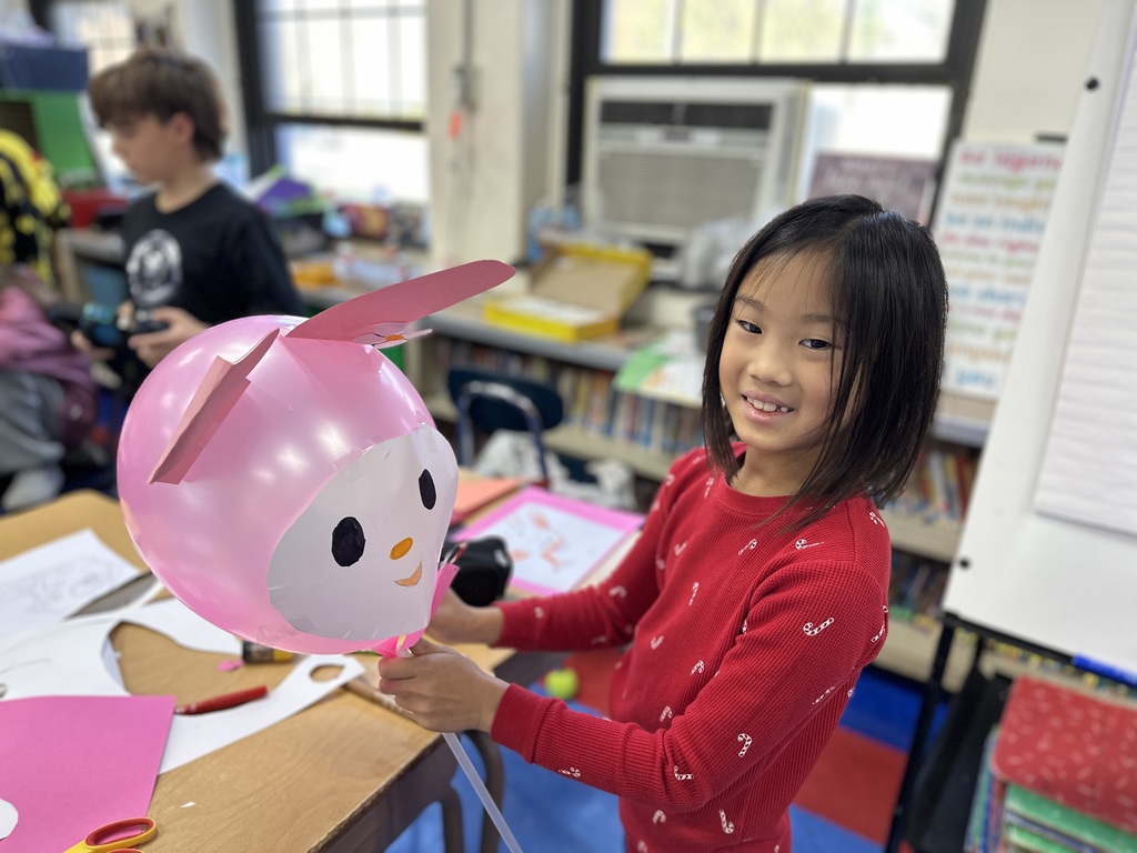 student holding their balloon design