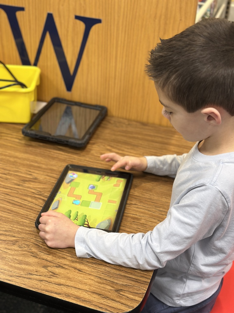 first grade student playing coding game