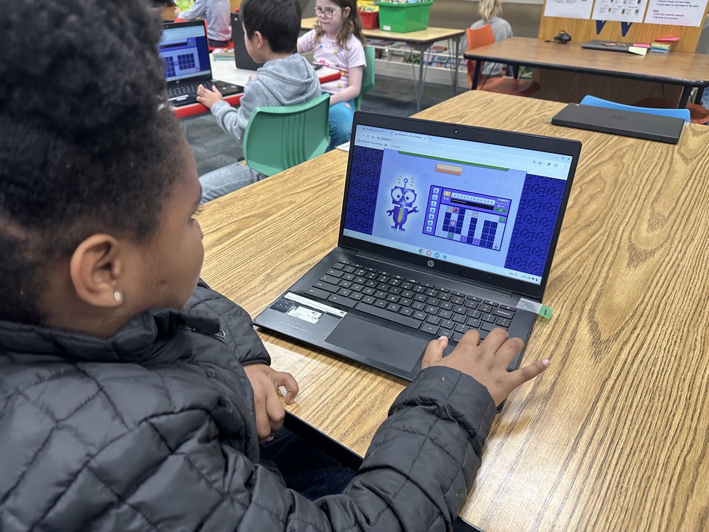 first grade student playing coding game
