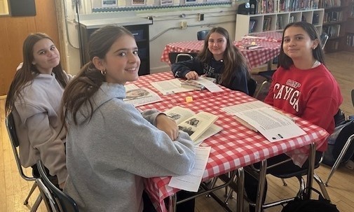 Four students smile for camera during "book tasting"