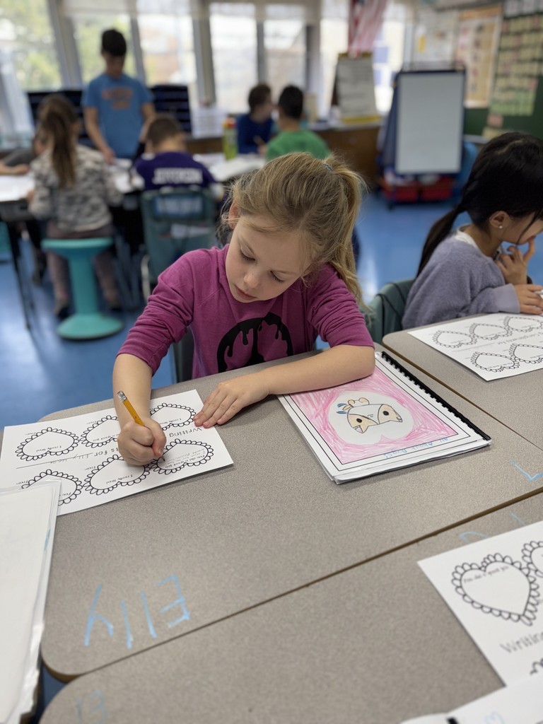 Student looks at published book and writes a note for the author. 