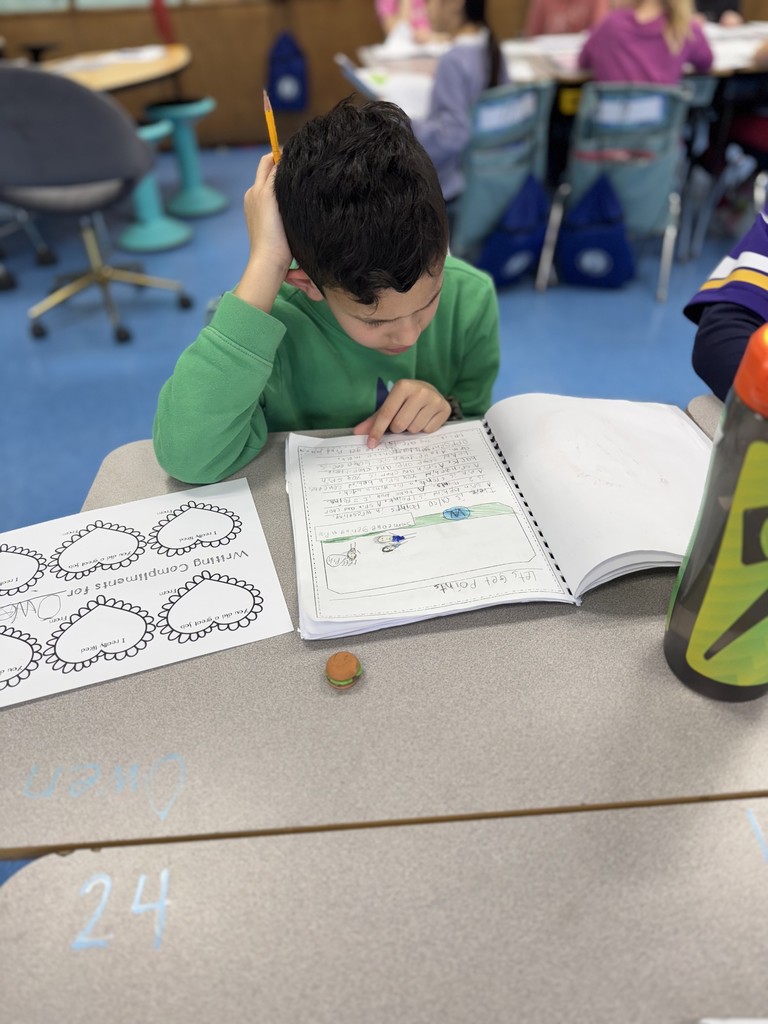 Student looks at published book and writes a note for the author. 