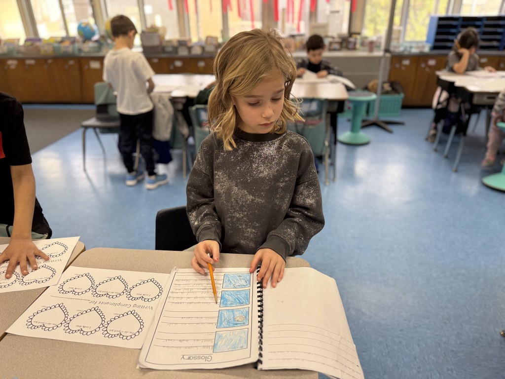 Student looks at published book and writes a note for the author. 
