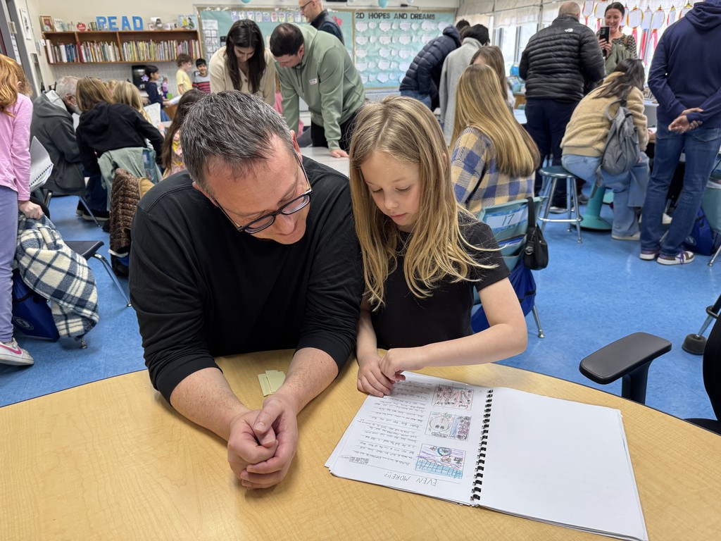 Parent and student looking at the published book.