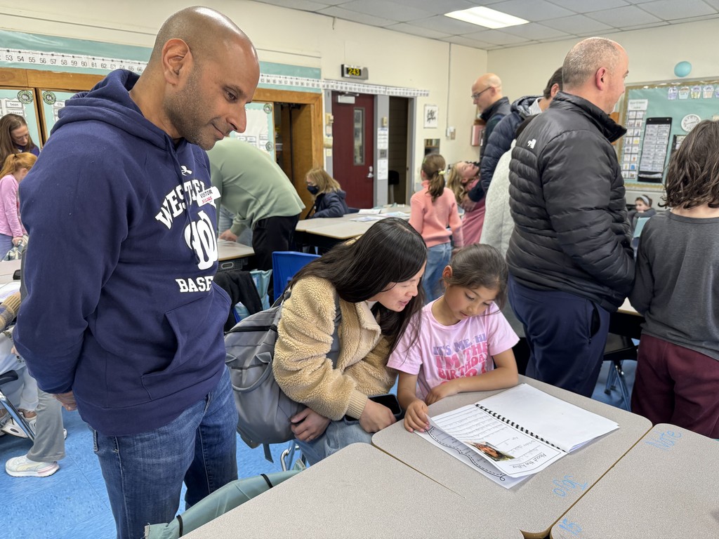 Parents admiring the student's writing.