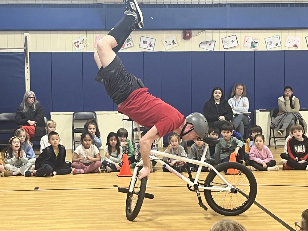 The presenter is doing a stunt on his bike.
