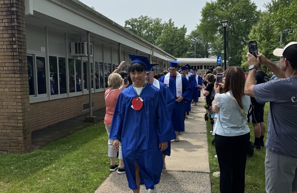 WHS 12th graders wear cap and gown as they walk thru clapout at elementary alma mater
