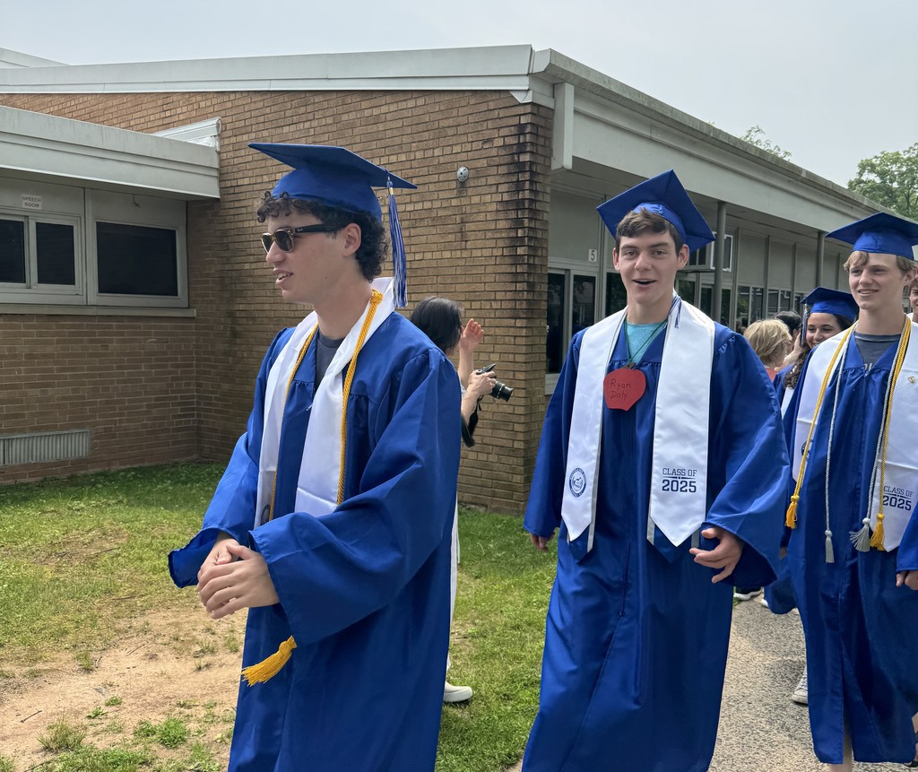 WHS 12th graders wear cap and gown as they walk thru clapout at elementary alma mater