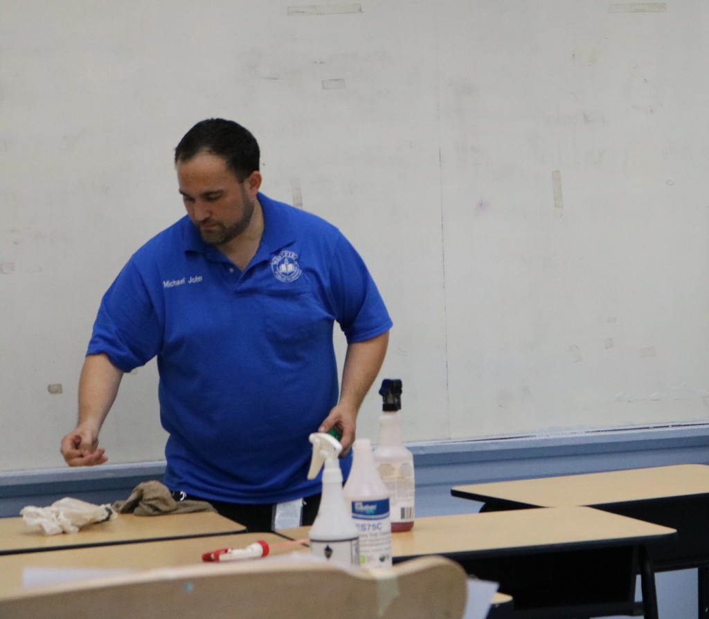Custodian cleaning desk