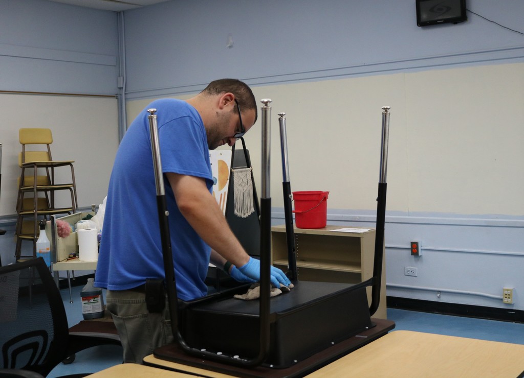Custodian cleaning desk