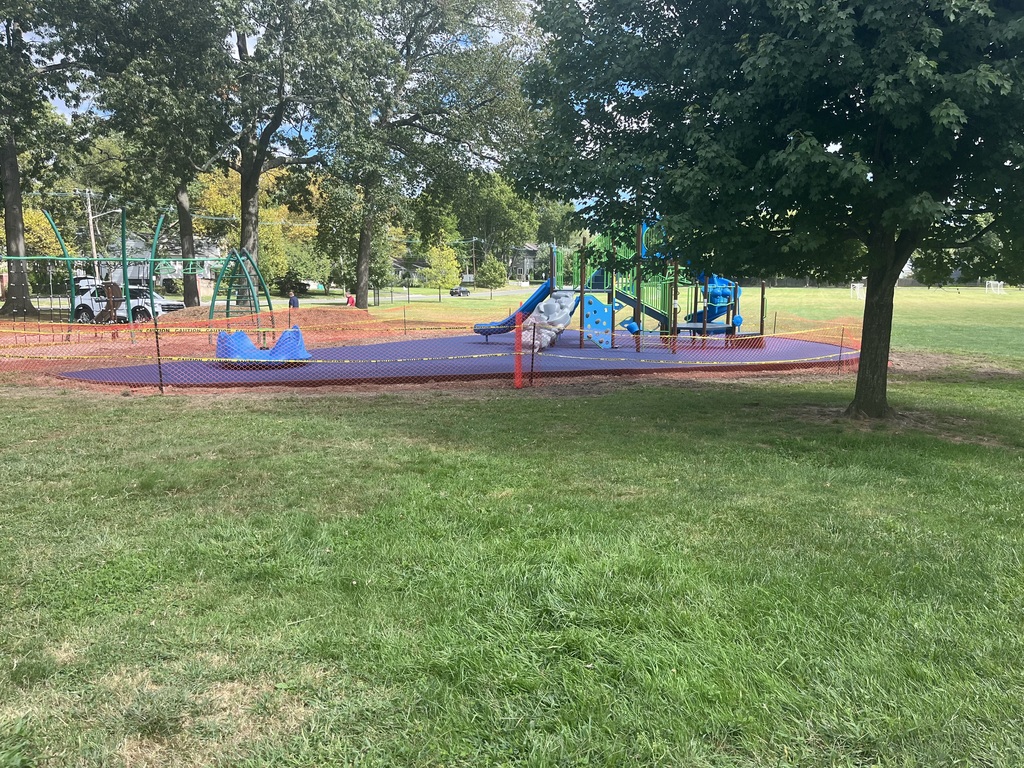 The playground is surrounded by the orange fencing so the rubber mulch surface can dry completely.