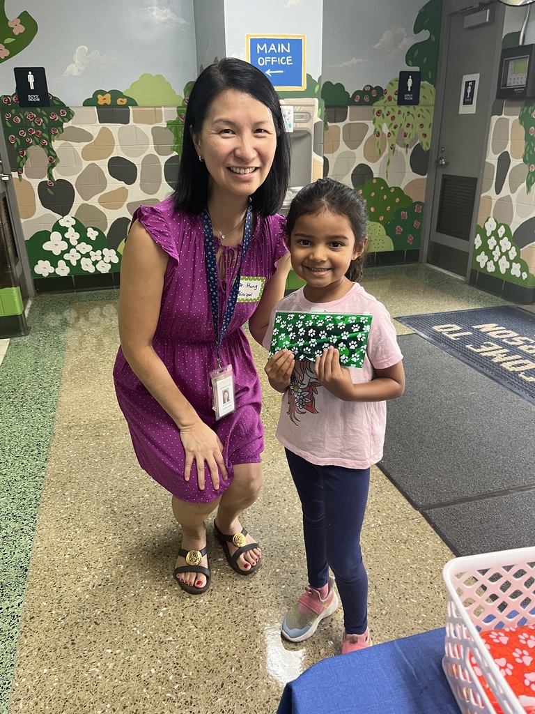 New first grader holds her pencil case and posing with the principal