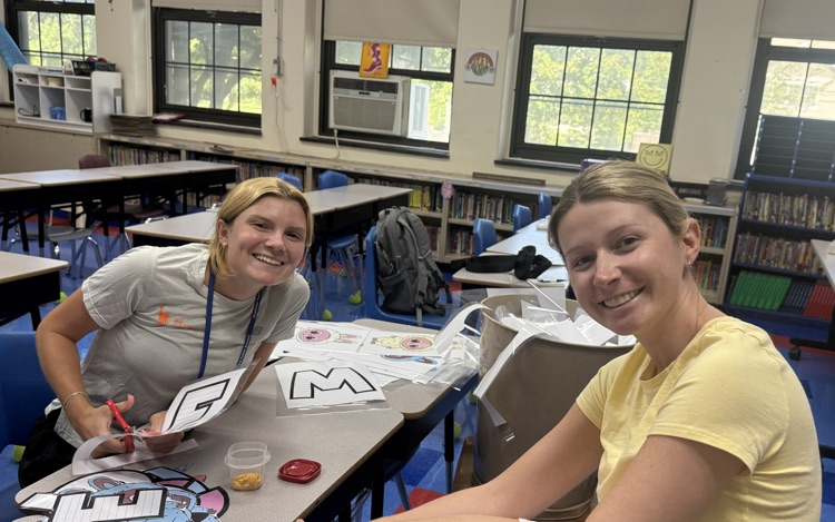 2 teachers working together, organizing their classroom