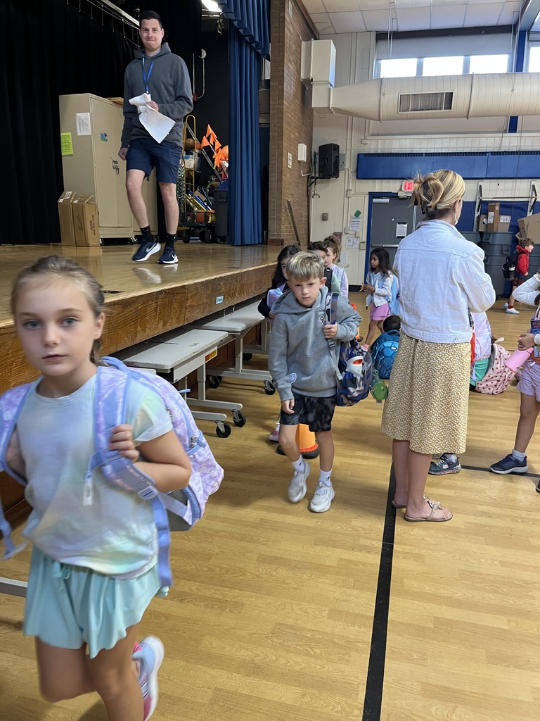 2nd graders exiting the gym and making their way to their classroom wit  their teacher.
