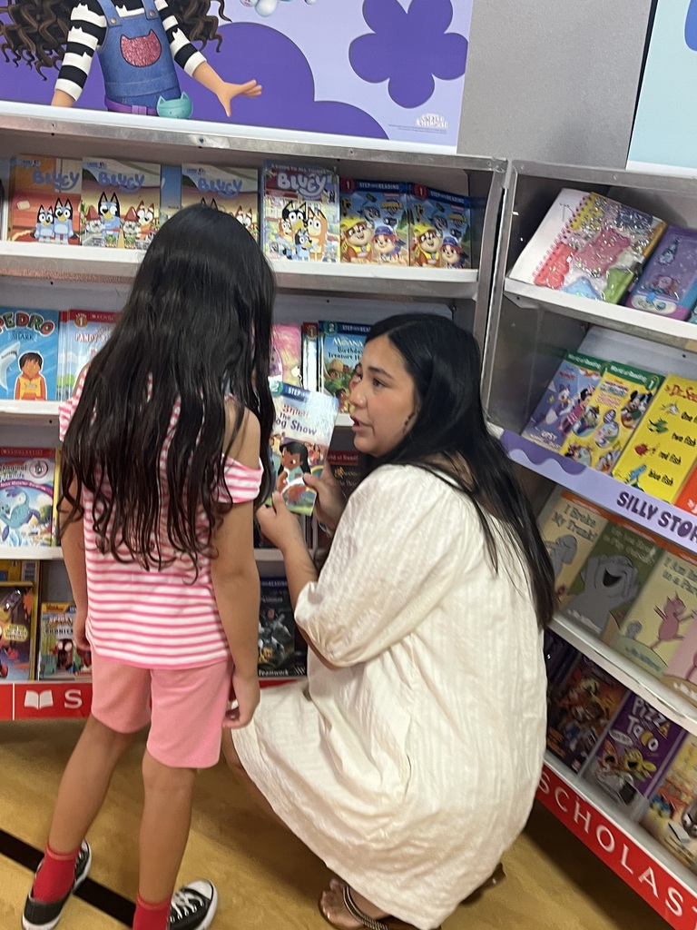 The teacher is helping the student with book selections.