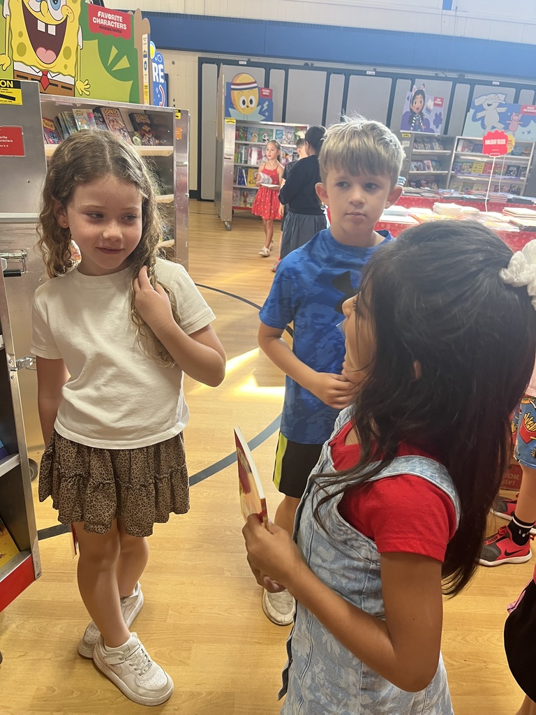 Second graders can't decide on which books to get yet.