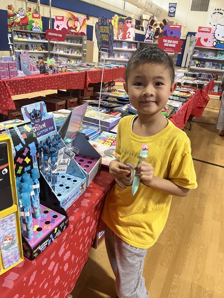 Student holds a special pen he sees at the book fair. 