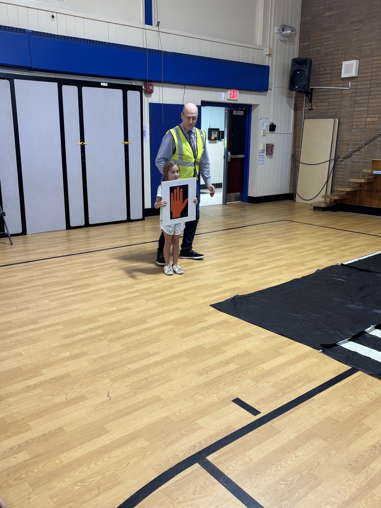 Presenters has a student volunteer hold the hand sign.