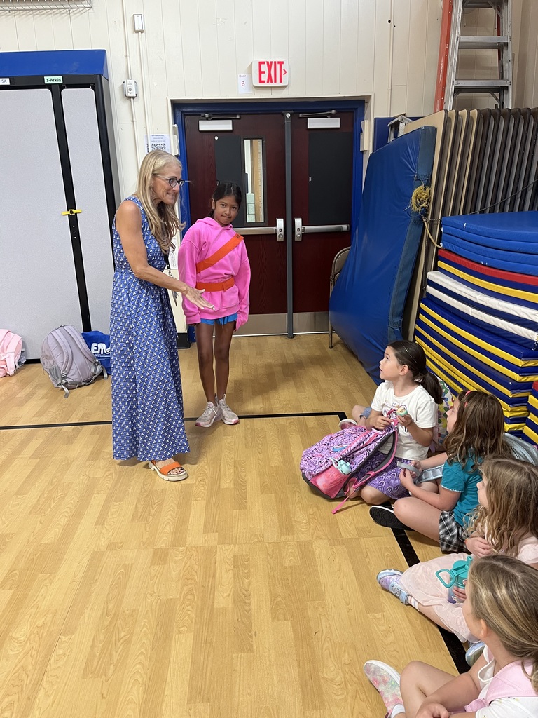 Teacher introduces safety patrol volunteer to the students.