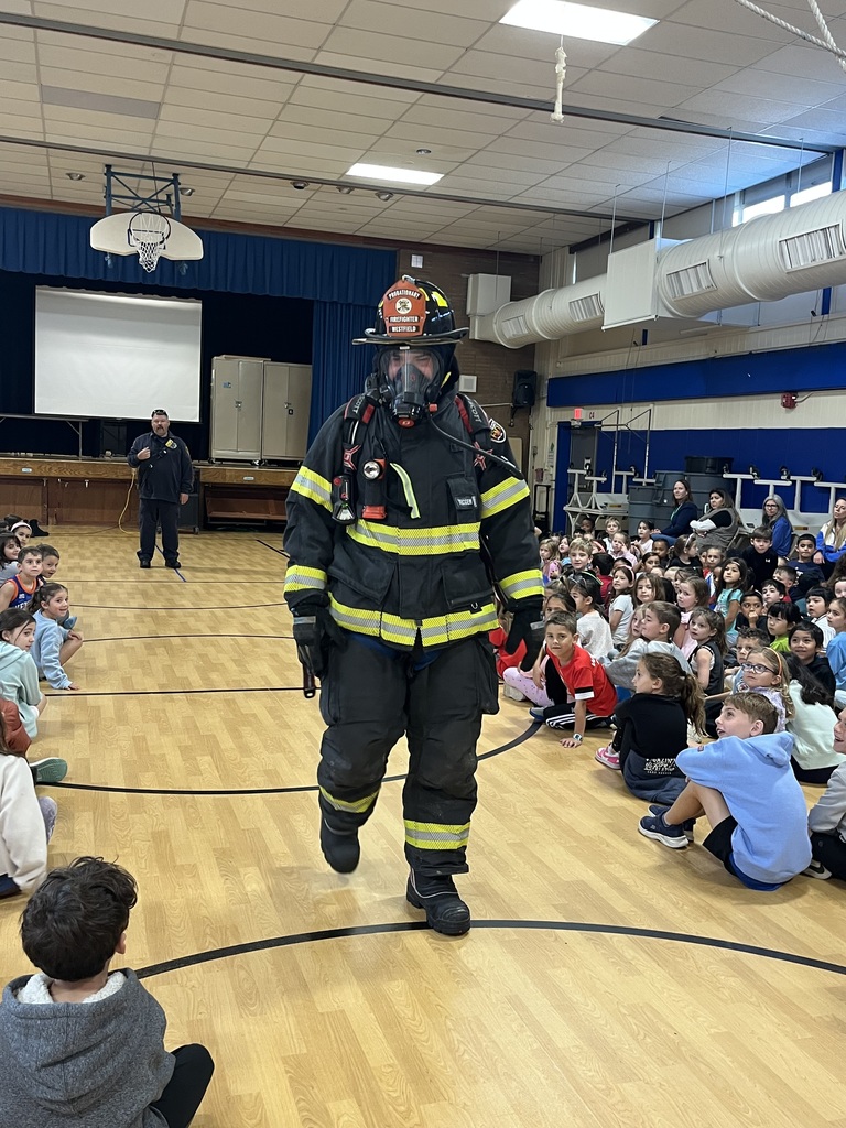 Fire fighter shows the children his full safety gear.