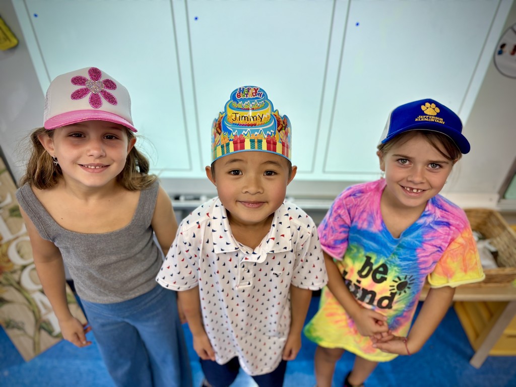 Students are wearing their hat and a birthday boy with his crown.