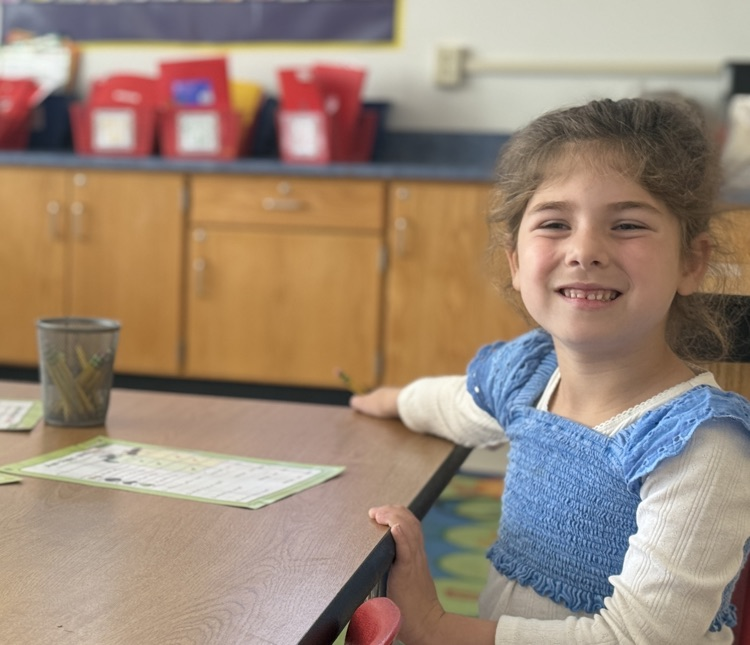 students collaborate with table mates to answer comprehension questions