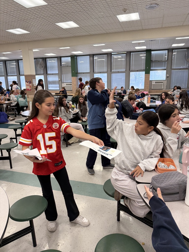 student handing paper to other student